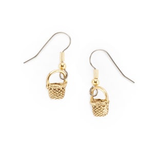 May include: Gold-tone basket-shaped dangle earrings with a silver hook. The earrings are small and delicate.
