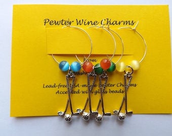 May include: Set of four pewter wine glass charms featuring a golf club design. Each charm is accented with a colorful glass bead in blue, orange, green, and yellow.