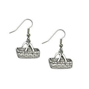May include: A pair of silver earrings featuring a detailed basket design. The earrings have a simple hook closure.
