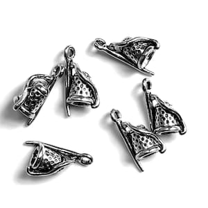 May include: A collection of silver-toned thimble charms, each with a detailed, textured design. The charms are scattered against a white background, showcasing their intricate patterns and small loop for attaching to jewelry or crafts. The thimbles are a classic sewing accessory.