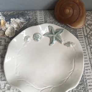 Freeform porcelain shell dish with celadon green shells.