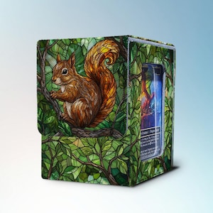 May include: A card storage box with a detailed illustration of a squirrel on a branch, surrounded by green leaves. The box has a clear window showing a card with a colourful design. The design has a nature theme.