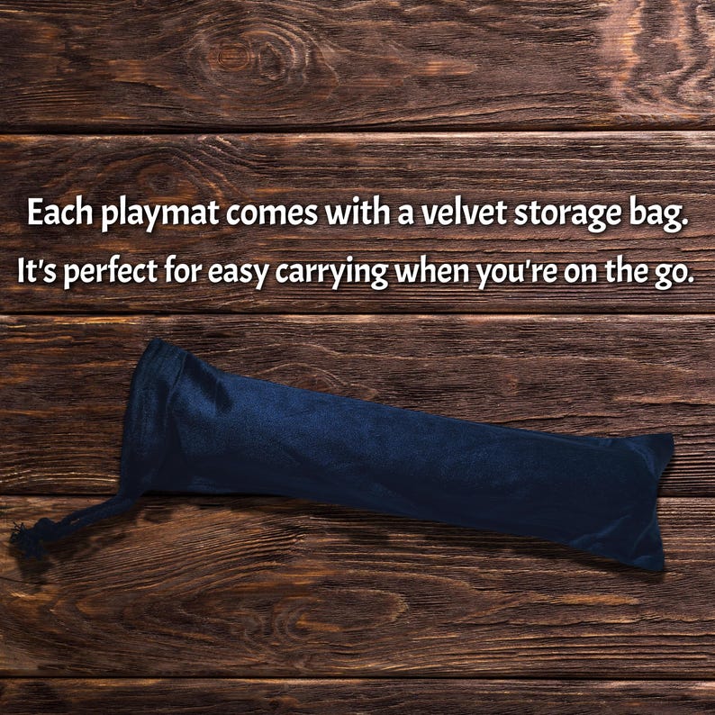 May include: A navy blue velvet storage bag for a playmat, lying on a dark wood surface. The bag is cylindrical with a drawstring closure. Text on the image reads: "Each playmat comes with a velvet storage bag. It's perfect for easy carrying when you're on the go."