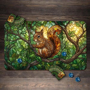 Könnte beinhalten: Spielmatte im Glasmalerei-Stil mit einem braunen Eichhörnchen auf einem Ast, umgeben von grünen Blättern und einer gelben Sonne. Enthält ein Kartenspiel und blaue Würfel. Das Design ist vor einem Holzgrund.
