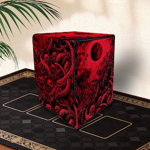Puede incluir: Una caja cuadrada para cartas coleccionables con un estampado gráfico en rojo oscuro y negro de calaveras, tentáculos y una luna llena. La caja tiene un diseño estructurado y vertical con una abertura superior y arte detallado de terror.