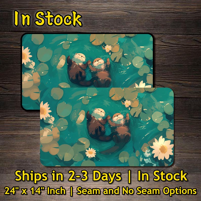 May include: Two rectangular mouse pads featuring an illustration of two otters floating in a pond with lily pads and flowers. The mouse pads are 24 inches by 14 inches. The text "In Stock" is at the top.