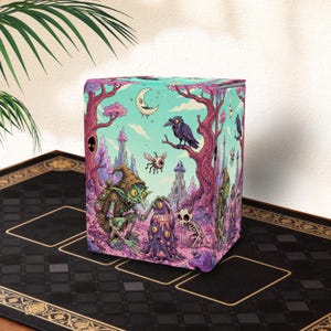 May include: A rectangular deck box featuring a vibrant, detailed illustration of a green goblin interacting with a multi-eyed creature in a surreal forest. The scene includes a crescent moon, a black raven, a flying eyeball, and a small skeleton.