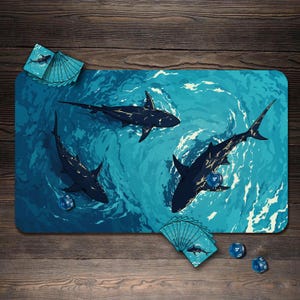 May include: A rectangular play mat depicting a blue ocean scene with three dark sharks. The mat includes a set of cards with a shark image and several blue dice. The background is a wooden surface.