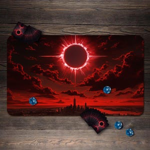 May include: A rectangular playmat with a dramatic red and black celestial design, featuring a glowing solar eclipse and a city skyline. Several blue dice and card decks with matching designs are scattered around the mat, set against a wooden background.