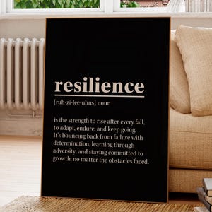 Puede incluir: Un marco negro con la palabra "resiliencia" en blanco, junto con su pronunciaci&oacute;n y definici&oacute;n. La impresi&oacute;n se muestra en una habitaci&oacute;n luminosa con una ventana y un sof&aacute; beige, creando un ambiente c&aacute;lido.