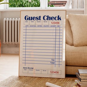 May include: A framed print of a guest check with the words "Guest Check" in blue. The check has lines for date, table, guests, server, and a section for food and beverage items. The number "123456" is printed on the check.