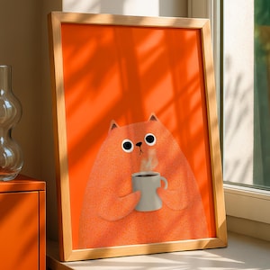 May include: A framed art print featuring a cartoon cat holding a steaming mug of coffee. The cat is orange with black eyes and a white nose, set against a bright orange background. The frame is made of light-colored wood.