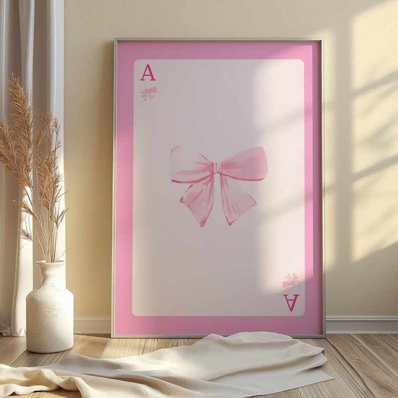 以下が含まれることがあります： ピンクの遊びカードにピンクのリボンと「A」の文字が書かれています