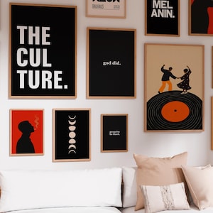 May include: A gallery wall featuring multiple framed prints including text-based art reading THE CULTURE, god did, and proud to be black, alongside illustrations of a person smoking, moon phases, and two people dancing on a vinyl record.