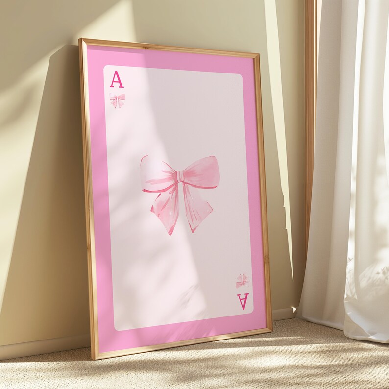 以下が含まれることがあります： ピンクのフレームに、ピンクのリボンと、リボンの両側に「A」の文字が印刷されています。