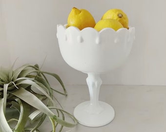 May include: White pedestal bowl with scalloped edges and a textured design. The bowl is filled with lemons.