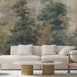 May include: A living room with a white sofa, armchair, and wooden chair. A round coffee table with a marble top and a forest mural wallpaper create a calm atmosphere. The room is decorated with neutral colours.