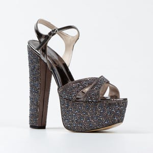 May include: A pair of gray platform sandals with a high heel. The sandals are covered in small, silver-toned beads.