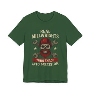 Op de afbeelding: Groen t-shirt met de tekst "REAL MILLWRIGHTS TURN CHAOS INTO PRECISION". De afbeelding toont een schedel met een rode baard en helm, gekruiste moersleutels en sterren.