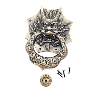 Puede incluir: Aldaba de puerta de dragón de latón antiguo con un asa redonda. El dragón tiene la boca abierta y está rodeado por un borde decorativo. Incluye herrajes de montaje.