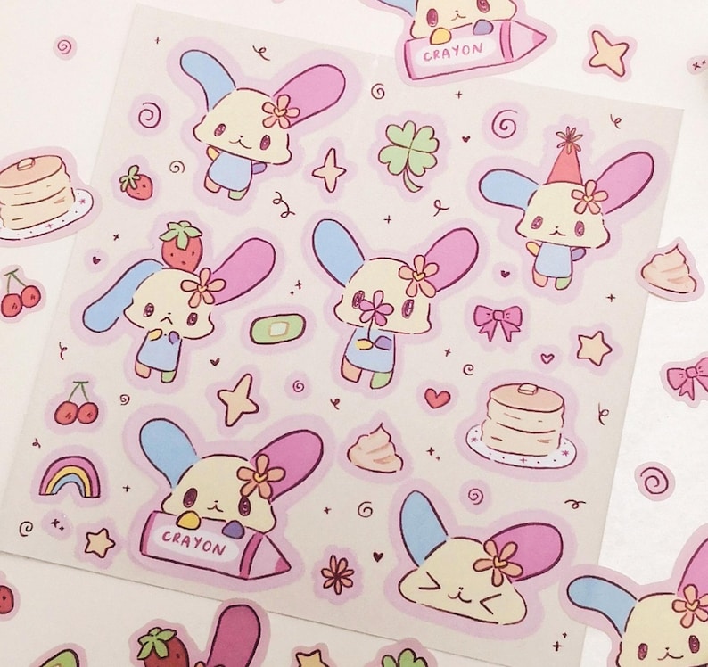May include: A sheet of stickers featuring cute cartoon characters with pastel colors and various designs, including hearts, stars, rainbows, and a cupcake. The stickers are perfect for adding a touch of whimsy to journals, planners, and other items.