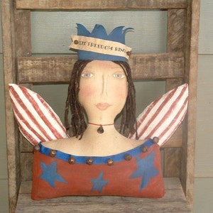 May include: A handmade patriotic doll with red, white, and blue wings, a blue crown with the text "My Freedom King", and a red, white, and blue star-patterned dress.