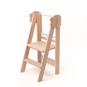 May include: A wooden step stool with two steps and a handrail. The stool is made of natural wood and has a light brown finish.