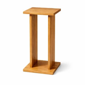 Peut inclure: Une table d'appoint en bois brun clair avec un plateau et une base carrés, reliés par deux supports rectangulaires verticaux. La table est en bois massif et a une finition naturelle. La table mesure environ 30 cm de large, 30 cm de profondeur et 61 cm de haut.