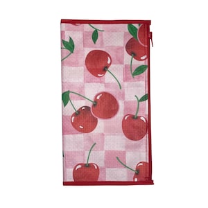 May include: A rectangular wallet featuring a pink and white checkered pattern with red cherries and green leaves. The wallet has a red border and a red zipper closure. The design is repeated across the surface.