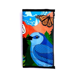May include: A blue bird with a long, pointed beak and a bright blue body is perched on a branch. The bird is surrounded by green leaves and a butterfly with orange and black wings. The background is a colorful illustration of a forest scene.