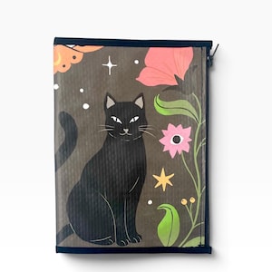 May include: A rectangular zippered pouch featuring a dark gray background with a black cat illustration. The design includes pink and orange flowers, green stems, yellow stars, and small white dots. The pouch has a dark blue trim along the edges.