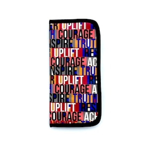 Puede incluir: Una bolsa negra con cremallera con un patrón colorido de las palabras "Uplift", "Courage", "Inspire" y "Truth" repetidas en varios colores.