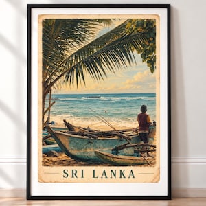 May include: A framed vintage-style travel poster featuring a beach scene in Sri Lanka. The image shows a person standing near weathered blue wooden fishing boats on the sand, with palm fronds overhead and the ocean in the background. The text SRI LANKA is printed in dark green at the bottom of the poster.