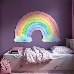 Könnte beinhalten: Ein Kinderzimmer mit einem großen, bunten Regenbogen-Wandaufkleber über einem Bett. Das Bett hat weiße Bettwäsche mit floralem Muster und einen rosa Rucksack. Die Wände sind lila, und der Raum hat ein Fenster mit rosa Vorhängen.