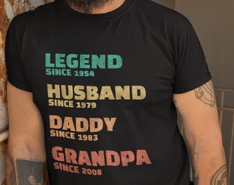 May include: Black t-shirt with a vintage-style graphic that reads "LEGEND SINCE 1954", "HUSBAND SINCE 1979", "DADDY SINCE 1983", and "GRANDPA SINCE 2008".
