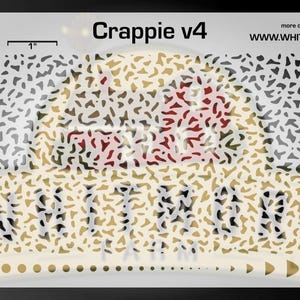 May include: A white stencil with the text "Crappie v4" and the Whitmore Farm logo. The stencil features a pattern of irregular shapes in shades of brown, gray, and red. The stencil includes a 1-inch measurement indicator.
