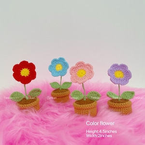 May include: Four crocheted flowers in terracotta pots with green leaves. The flowers are red, blue, pink, and purple with yellow centers. The text "Color flower" is visible, with dimensions of 4.5 inches in height and 2 inches in width.