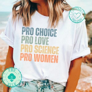 Könnte beinhalten: Ein weißes T-Shirt mit dem Text "Pro Choice Pro Love Pro Science Pro Women" in einem Regenbogen-Farbschema. Der Text ist in einer Schriftart im Vintage-Stil.