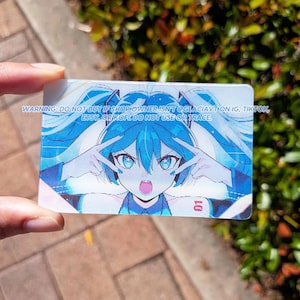 May include: A rectangular card featuring an anime-style character with long blue hair, blue eyes, and a headset, making peace signs with both hands. The text reads: WARNING: DO NOT BUY IF SHOP OWNER ISN'T @GLACIAVT ON IG, TIKTOK, ETSY, OR KOFI. DO NOT USE OR TRACE.