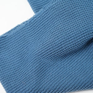 Peut inclure: Gros plan sur un tissu bleu tricoté avec un motif texturé.