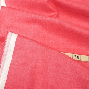 Könnte beinhalten: Nahaufnahme eines leuchtend roten Stoffes mit Leinenstruktur. Der Stoff ist gefaltet und ein Lineal ist mit den Zahlen 4, 20 und 15 sichtbar. Der Stoff hat ein weißes Etikett mit dem Text "1473 Linen Texture 4/0".