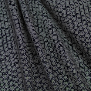 Peut inclure: Tissu noir avec un motif géométrique blanc de petites étoiles. Le tissu est plié et a une texture douce.