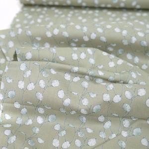 Peut inclure: Tissu vert sauge avec un motif floral blanc et bleu. Le tissu a une texture subtile et une sensation douce et naturelle.