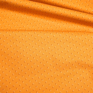 May include: Orange fabric with a small white polka dot pattern. The fabric is folded in half and the fold is visible in the centre of the image.
