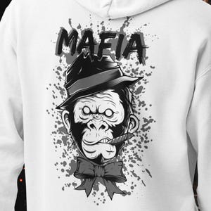 May include: A white hooded sweatshirt featuring a graphic on the back of a gorilla wearing a fedora hat and a bow tie with a cigar in its mouth. Above the gorilla, the word MAFIA is printed in bold black letters against a grey paint splatter.