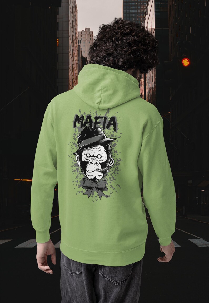 May include: A light green hooded sweatshirt featuring a graphic on the back of a gorilla wearing a black fedora and a bow tie with a cigar in its mouth. The word MAFIA is printed in black above the gorilla, set against a grey paint splatter design.
