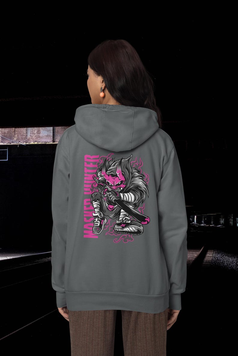 May include: A charcoal gray hooded sweatshirt featuring a graphic on the back of a pink-skinned, horned creature holding a sword. The text MASKED HUNTER is printed vertically in pink next to the illustration, which includes pink smoke accents.