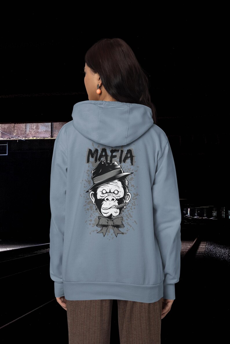 May include: A light blue hooded sweatshirt featuring a graphic on the back of a gorilla wearing a fedora hat and a bow tie with a cigar in its mouth. The word MAFIA is printed in black above the gorilla, surrounded by a gray splatter design.
