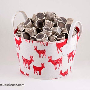 May include: A white fabric storage basket with red reindeer print and white handles filled with coffee pods.
