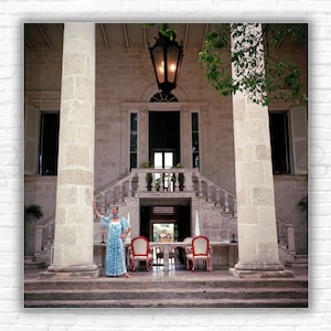 Stampa/Poster Lady Of The Manor di Slim Aarons: Lee MacLaren posa sui gradini di una grande villa in pietra a Barbados, aprile 1976.